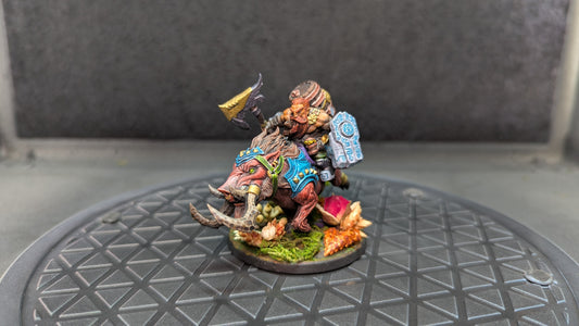 Miniature Dwarf warrior on a warthog running through lush green vegetation. 3D printed and hand painted to display level.